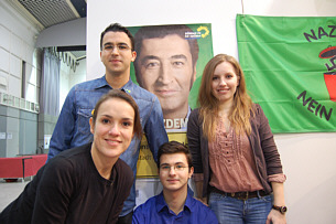 Besucherinnen und Besucher des TURKU Festivals vor Cem Özdemir-Plakat Aktionsfoto 1