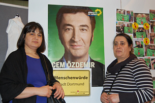 Besucherinnen des TURKU Festivals vor Cem Özdemir-Plakat Aktionsfoto 1